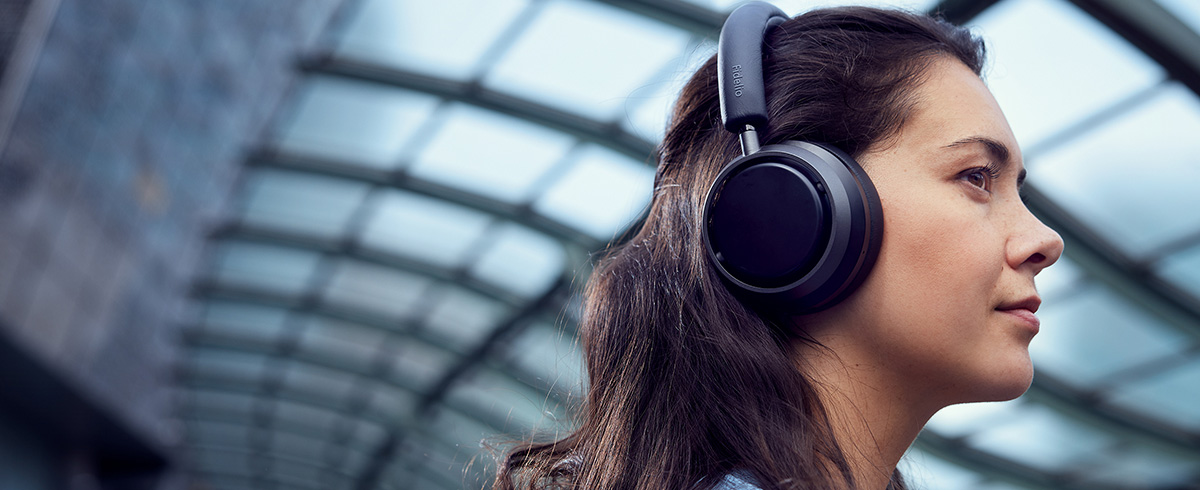 Femme &eacute;coutant de la musique en voyage &agrave; l'aide d'un casque Philips L4
